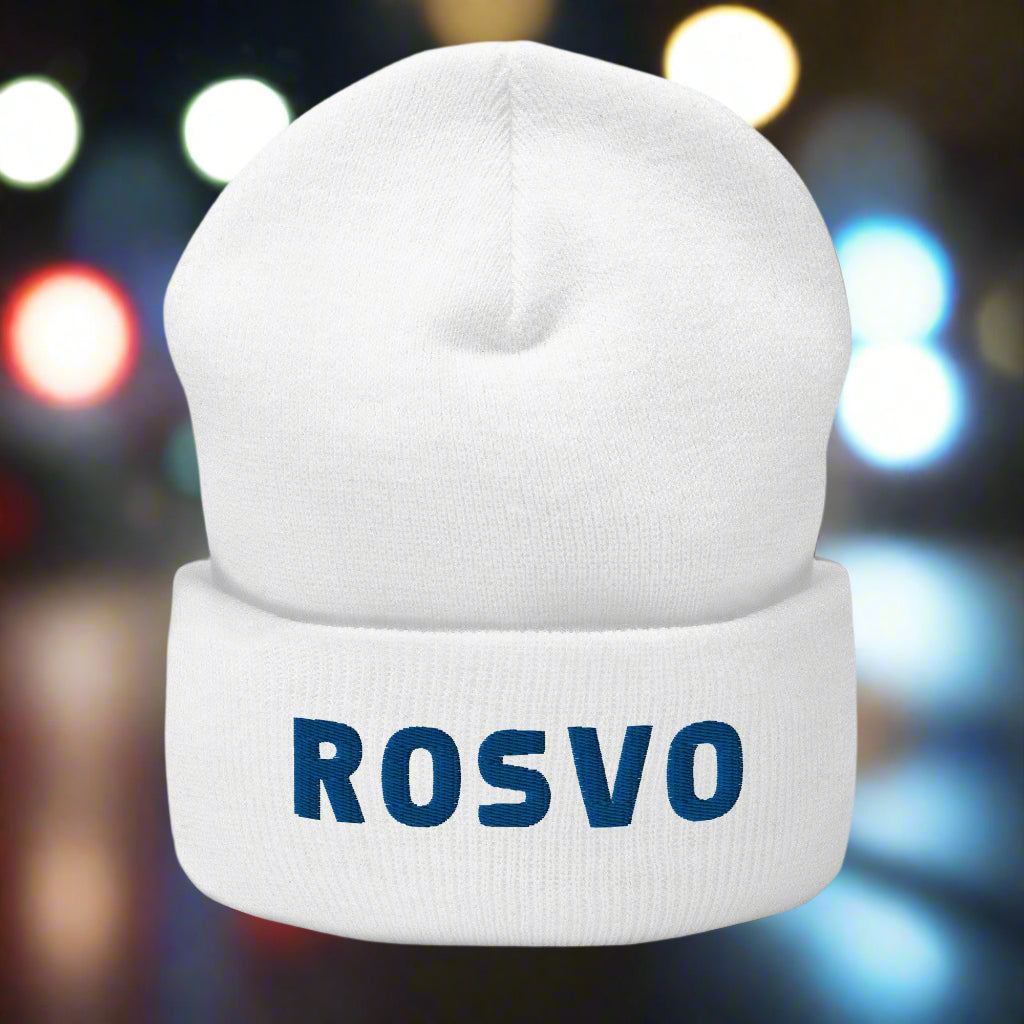 Hymyilevä partainen mies käyttää Meemirottan harmaata Rosvo Pipo -pipoa, jossa on sinisillä kirjaimilla "ROSV", joka on ihanteellinen ainutlaatuisia lahjaideavaihtoehtoja etsiville. Hänellä on myös valkoinen collegepaita ja hän seisoo valkoista tiiliseinää vasten.